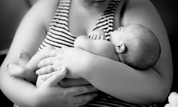 Mutter mit neugeborenem Kind im Arm
